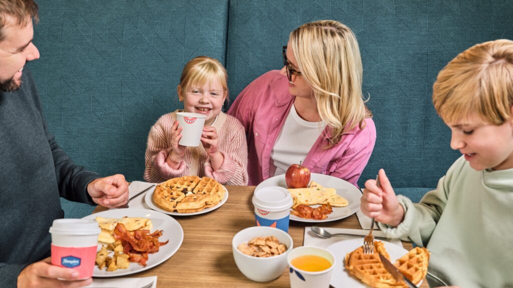 A family eating waffles at breakfast at a Hilton hotel property