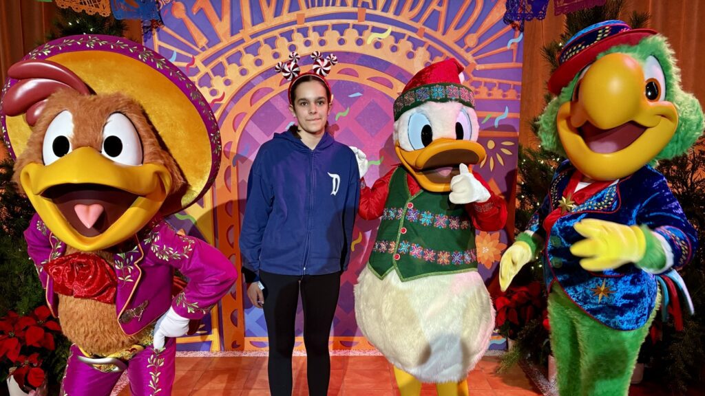 Teen posing with holiday Disneyland characters