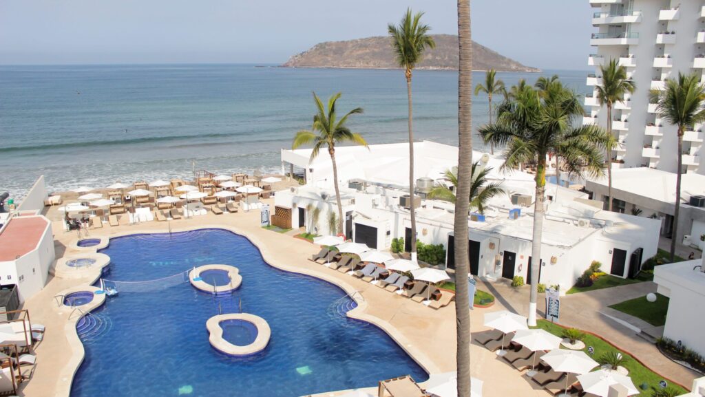 A view of the pool and beach at Sunvivia Mazatlán