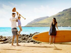 A family in the beach with a paddleboard at The Royal Sonesta Kauai Resort Lihue