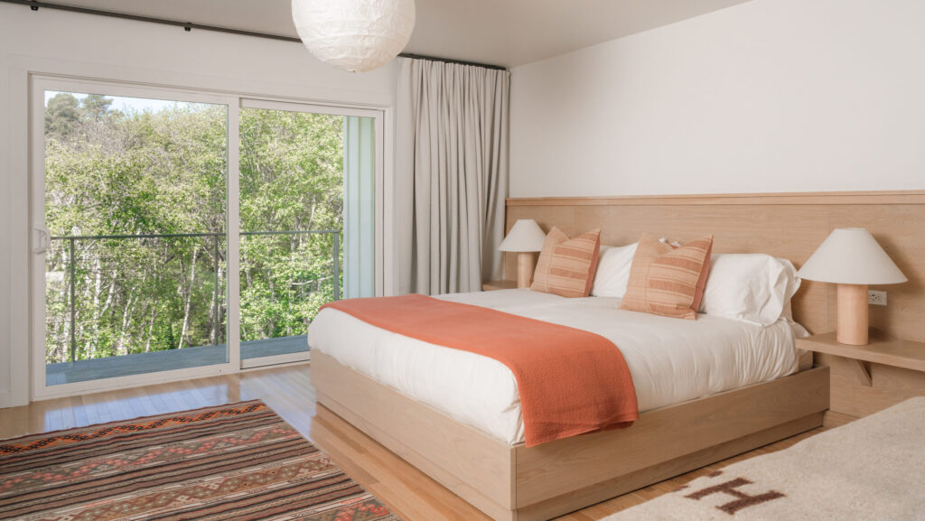A guest room with lots of natural wood and woodsy views at Mendocino Cove
