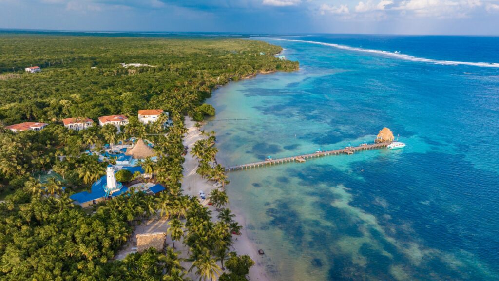 An aerial view of a dock stretching out into turquoise water at Reef Haven Belize