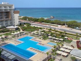 View from a guest room at the Embassy Suites Aruba Resort looking out over the pool toward the beach
