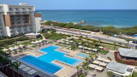 View from a guest room at the Embassy Suites Aruba Resort looking out over the pool toward the beach