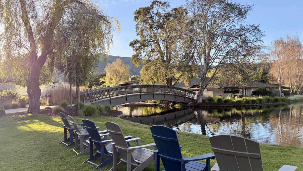 Adirondack chairs overlook the water and golf course at The Quail in Carmel Valley California