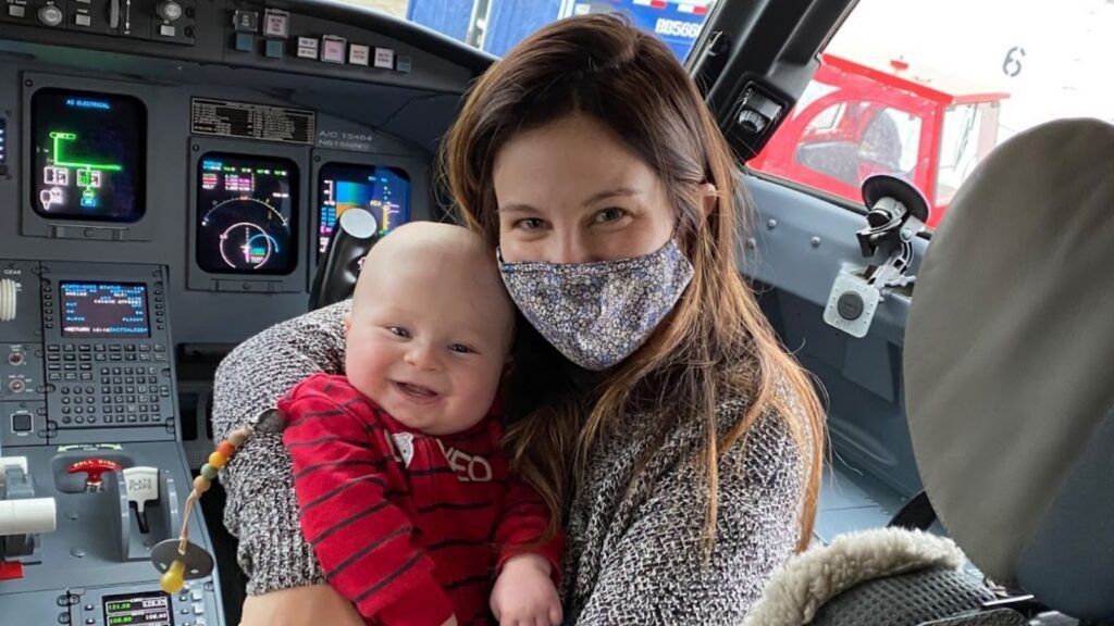 parents and baby on baby's first flight, posing in the cockpit
