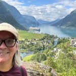 Kate Loweth posing for a selfie in Skjolden with the Holland America Rotterdam in the distance