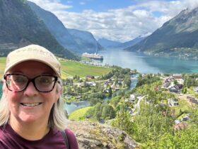 Kate Loweth posing for a selfie in Skjolden with the Holland America Rotterdam in the distance