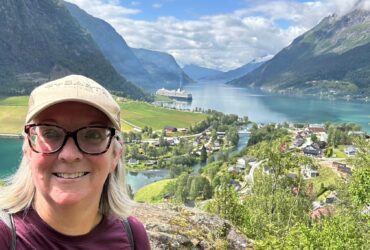 Kate Loweth posing for a selfie in Skjolden with the Holland America Rotterdam in the distance