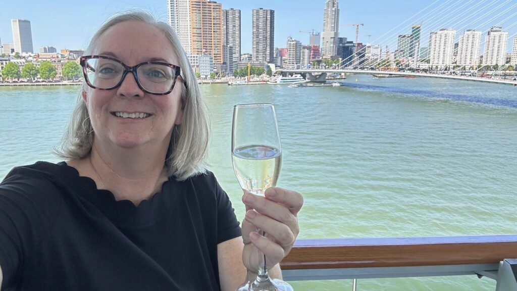 Kate Loweth with a glass of champagne toasting the sailing of the Rotterdam