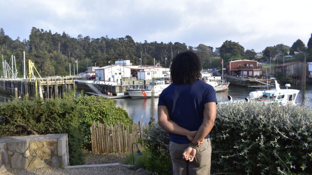 person looking out at Fort Bragg harbor from Noyo Harbor Inn