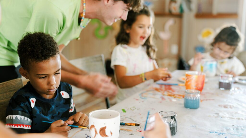 Three kids painting at Montage Palmetto Bluff's kids program