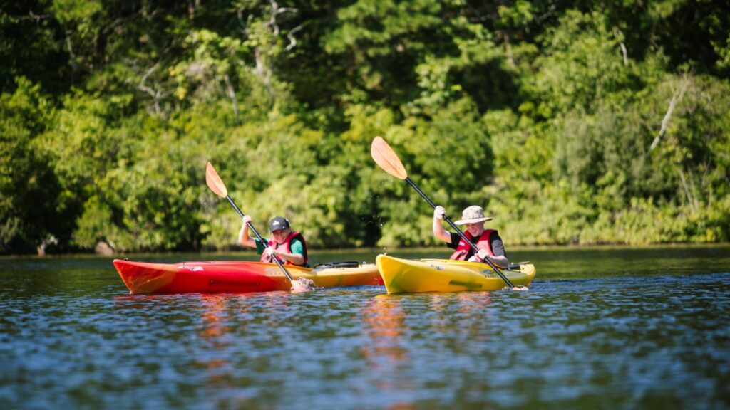 Two kids kayaking on Blueberry Pond at Ocean Edge Resort & Golf Club