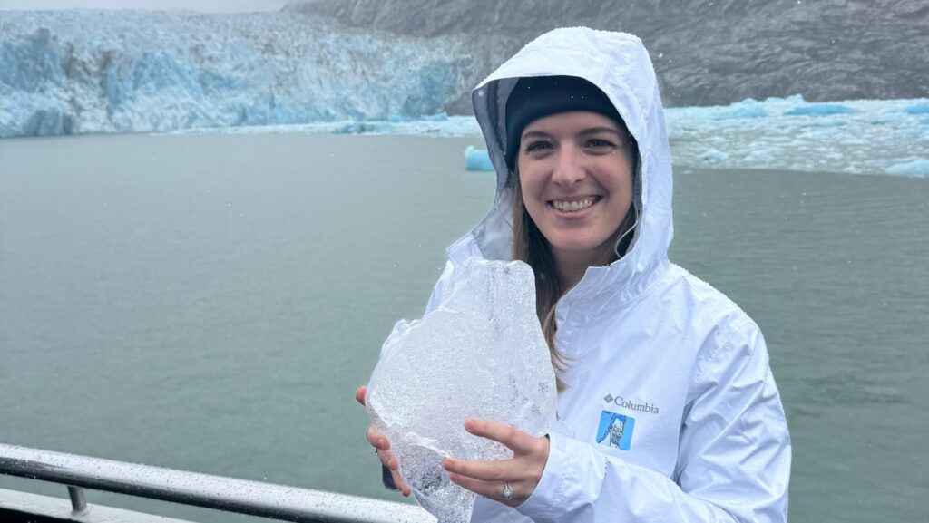 Theme park journalist Carly Neil holding a piece of glacier ice on our Glacier Day Port Adventure with Disney Cruise Line