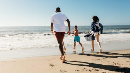 A family running toward the water's edge in Torrance, CA