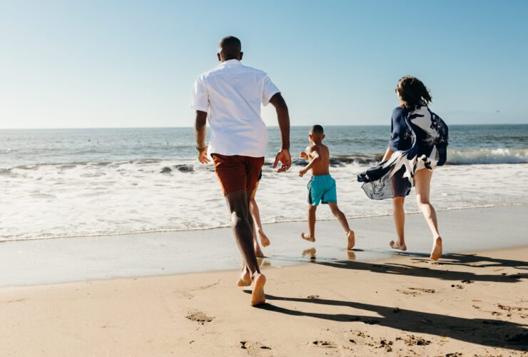 A family running toward the water's edge in Torrance, CA